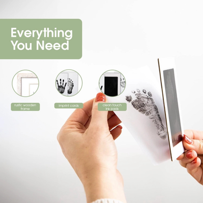 Complete BabyPrints kit including rustic frame, ink pad, imprint card, and mounting hardware arranged neatly on a flat surface.