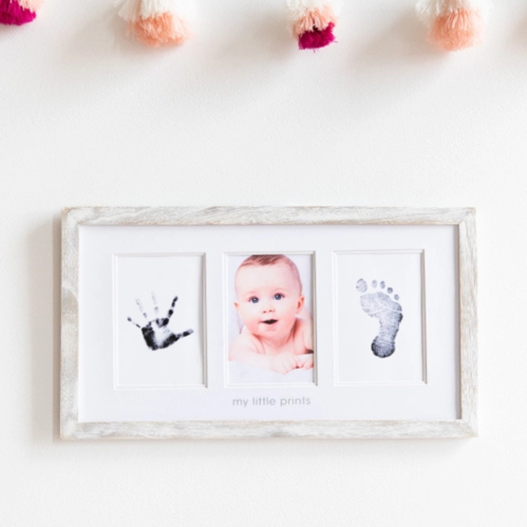Rustic wood frame displaying two newborn photos alongside a perfectly captured baby handprint.