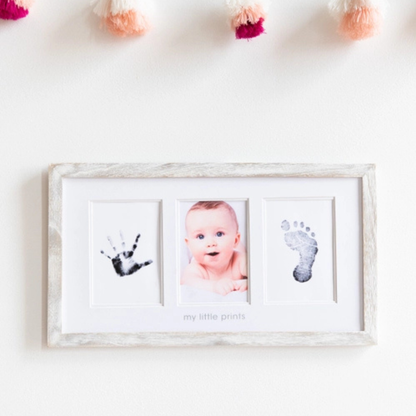 Rustic wood frame displaying two newborn photos alongside a perfectly captured baby handprint.